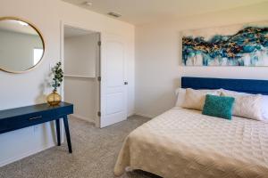 een slaapkamer met een blauw bed en een spiegel bij Luxurious Laredo Getaway - Unwind in Style! in Laredo