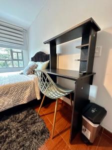 - un bureau dans une chambre avec un lit et un sèche-cheveux dans l'établissement Habitacion cerca al aeropuerto el dorado, à Bogotá