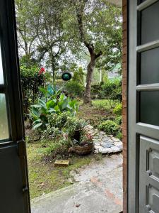 une porte ouverte sur un jardin avec des fleurs et des plantes dans l'établissement Habitacion cerca al aeropuerto el dorado, à Bogotá
