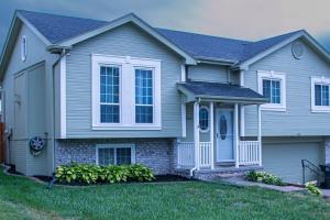 a gray house with a blue door at Pet friendly,3 Queen beds, One-Full bed with Fast free WIFI in Omaha