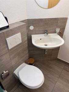 La salle de bains est pourvue de toilettes blanches et d'un lavabo. dans l'établissement Studio Wohnung Küche,Bad,inklusive Stellplatz im Zentrum RV, à Ravensbourg