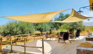 a large yellow umbrella on a wooden deck at Lovely Country House in Trappeto