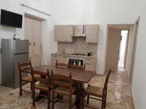 a kitchen with a table and chairs and a refrigerator at Casa Storico Centro in Marsala