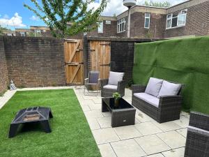 een patio met 2 stoelen en een tafel in de tuin bij 5 Bed 5 Bath / Brick Lane Central London E1 in Londen