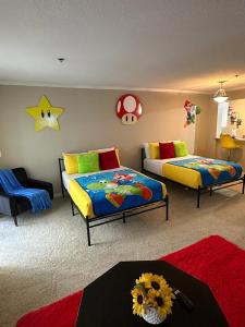 a bedroom with two beds and a table with flowers at Súper Mario Universal Studios 10 min Loft Free parking in Los Angeles