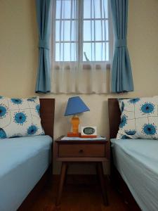 八王子市にあるGuest house with host Takao SORA- Vacation STAY 13000のベッドルーム1室(ベッド2台、ランプ付きテーブル付)