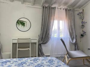 een slaapkamer met een bed, een bureau en een raam bij La Petite Maison in Usigliano