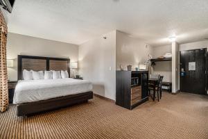 a hotel room with a bed and a desk at Days Inn & Suites by Wyndham Traverse City in Traverse City