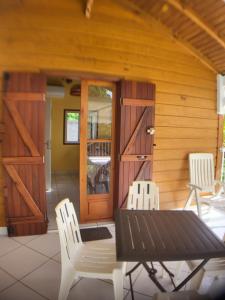 eine Terrasse mit 2 Stühlen, einem Tisch und einer Tür in der Unterkunft bungalow Bô Sicrié in Le Moule