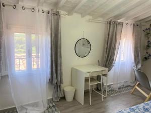 1 dormitorio con escritorio, espejo y ventana en La Petite Maison, en Usigliano