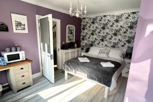 a bedroom with purple walls and a bed and a microwave at HighTree House in Cork