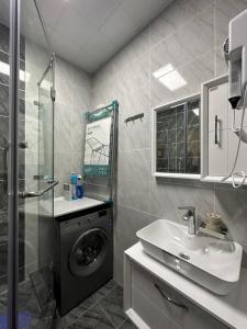 a bathroom with a washing machine and a sink at Dushanbe City View Apartments in Dushanbe