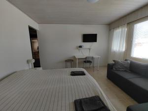 a white bedroom with a large bed and a couch at New studio near amenities in Varpaisjärvi in Varpaisjärvi