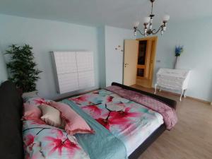 ein Schlafzimmer mit einem großen Bett mit Blumen darauf in der Unterkunft Huis Rochelle in Bredene