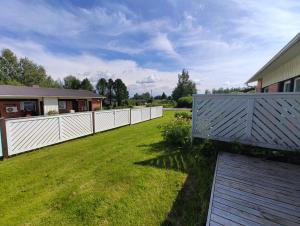 uma cerca branca num quintal ao lado de uma casa em New studio near amenities in Varpaisjärvi em Varpaisjärvi