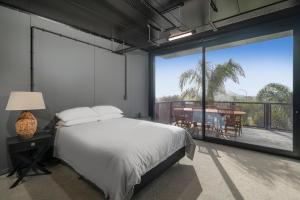 a bedroom with a bed and a large window at Panorama Vista in Pauanui