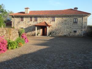 a stone house with a red roof and a driveway at Quinta Dom José Turismo Rural in Braga