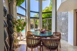 Huelo的住宿－Opulent Waterfall House with Ocean Views in Haiku, Maui，一间设有玻璃桌和椅子的用餐室