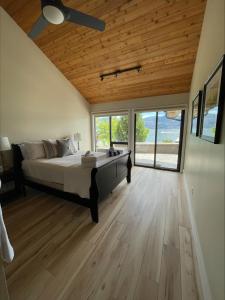 a bedroom with a large bed with a wooden ceiling at Lake House at Quails' Gate Winery in West Kelowna