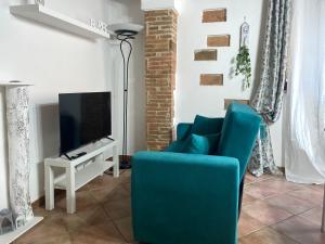 un soggiorno con divano blu e TV di B&B L'angolino a Usigliano