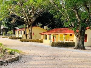 a building with a red roof next to a street at Cabañas Marisol in Palenque