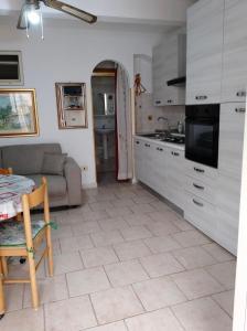a kitchen with a table and a couch and a kitchen with a table at Casa Vacanze Calabria in Tropea