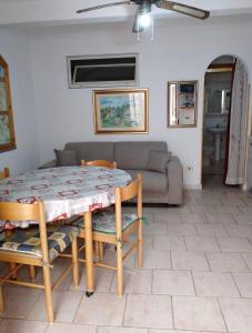 uma sala de estar com uma mesa e um sofá em Casa Vacanze Calabria em Tropea