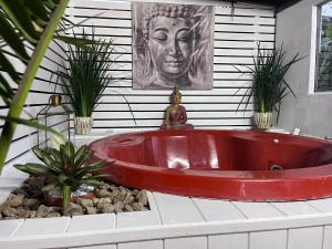 bañera roja en una habitación con plantas en PAZ Y ARMONÍA en chuy 2, en Chuy