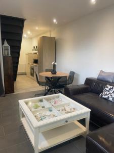 a living room with a couch and a table at Paisible Duplexe sur Villeneuve d ascq in Annappes