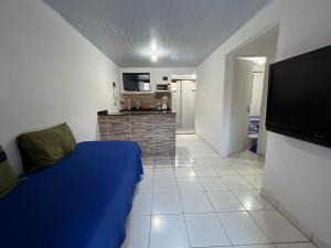 a bedroom with a blue bed and a tv at Chalé em Tamandaré in Tamandaré