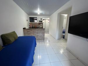 a living room with a couch and a flat screen tv at Chalé em Tamandaré in Tamandaré