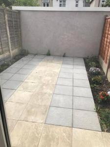 a patio with a stone floor next to a wall at 30A Mortlake in London