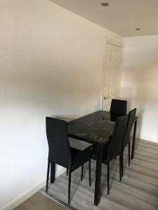 a black dining room table with four black chairs at 30A Mortlake in London