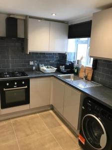 a kitchen with a washer and a sink and a dishwasher at 30A Mortlake in London
