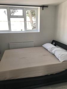 a large bed in a room with a window at 30A Mortlake in London