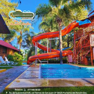 uno scivolo d'acqua in piscina in un resort di Parque Girasoles Balneario & Cabañas a San Francisco del Rincón