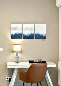 a desk with a chair and three paintings on the wall at Mein Apartment, Forest View, bis 10 Personen in Bad Kreuznach