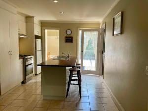 a kitchen with a counter and a sink and a stool at Barnard street Cottage in Bendigo