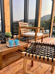 a porch with two chairs and tables on a balcony at Mount Log Cabin in Mavrovo