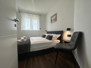 a bedroom with a bed and a chair in it at Apartments Pina in Kornić