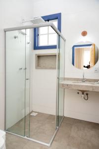 a glass shower in a bathroom with a sink at Pousada Pouso de Laura in Tiradentes