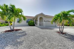 a house with two palm trees in front of it at Sunny Marco Island House Less Than 3 Blocks to Beach! in Marco Island