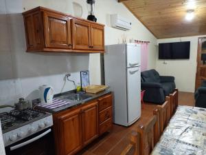 een keuken met een witte koelkast en een spoelbak bij Apart Morel in Puerto Iguazú