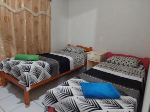 Pokój z 2 łóżkami, stołem i niebieską poduszką w obiekcie Apart Morel w mieście Puerto Iguazú
