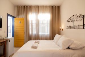 a bedroom with a large white bed with towels on it at Pousada Pouso de Laura in Tiradentes