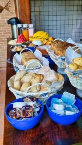 a table topped with lots of different types of bread at Pousada Jardon Ubatuba in Ubatuba