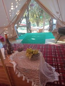 una mesa con un tazón de uvas y dos copas de vino en Yurta con uso piscina e vista meravigliosa, en Dicomano