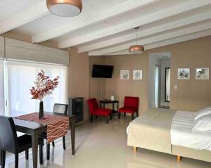 a bedroom with a bed and a table and chairs at Cabaña de los Colibríes in Esquel