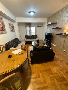 een woonkamer met een tafel en een bank bij Big apartment 2 in Podgorica