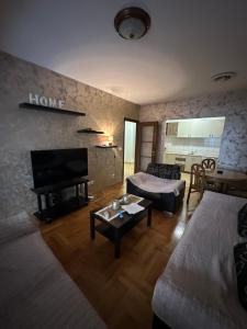 uma sala de estar com duas camas e um sofá em Big apartment 2 em Podgorica